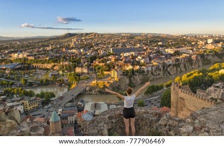Aerial view of old Tbilisi. Georgia - happy tourist with her arms folded