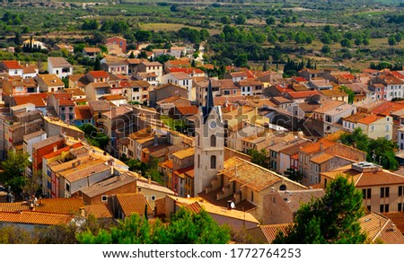 an aerial view of the old town of Leucate, in France, highlighting the belfry of the Our Lady of the Assumption Church over the tiled roofs of the houses of the village