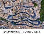 Aerial view of the old town of Ragusa Ibla and a winding road. View from above of the city in Ragusa Ibla, Province of Ragusa, Val di Noto, Sicily, Italy. 