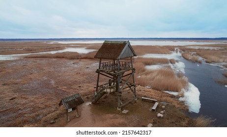 An aerial view of an old wooden watchtower by a swamp under a blue cloudy sky in Jurmala, Latvia