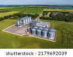 aerial view on agro silos granary elevator with seeds cleaning line on agro-processing manufacturing plant for processing drying cleaning and storage of agricultural products, flour and grain. 