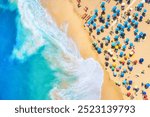 Aerial view on the beach, people and umbrellas. Vacation and adventure. Beach and blue water. Top view from drone at beach and azure sea. View on the coast from drone.