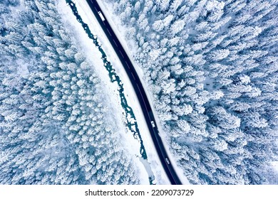 Aerial View On A Car Driving On Winter Country Road In Snowy Forest