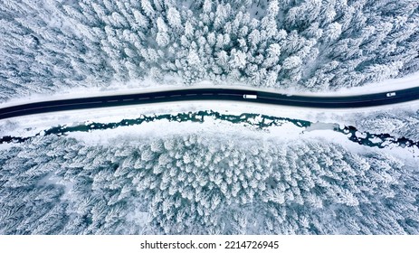 Aerial view on a car driving on winter country road in snowy forest - Powered by Shutterstock