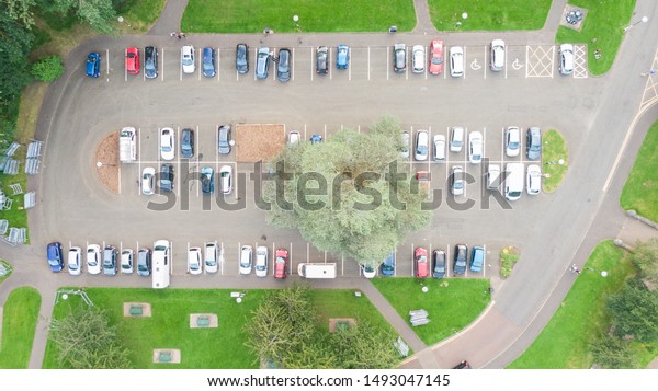 Aerial\
view on car park, cars parked on parking in row\
