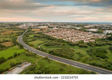 Aerial View On A City Residential Area With Houses And Park And Highway. Galway, Ireland. Blue Cloudy Sky. High Density Urban Land.