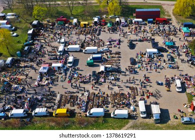 Aerial view on flea market with miscellaneous items and crowds of buyers and seller's makeshift stands.