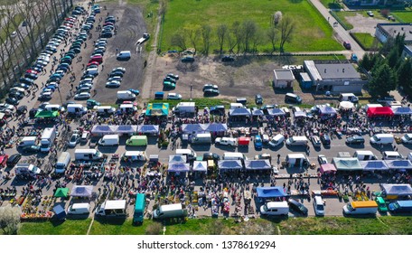 Aerial view on flea market with miscellaneous items and crowds of buyers and seller's makeshift stands.