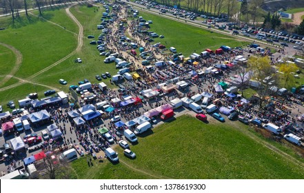 Aerial view on flea market with miscellaneous items and crowds of buyers and seller's makeshift stands.