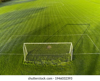 Aerial View On A Green Grass Football Or Soccer Field . Long Shadows On The Ground. Nobody. Training Pitch. Day Time