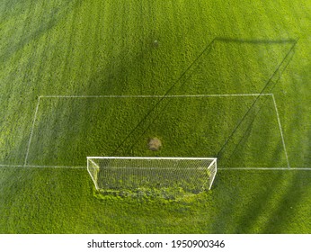 Aerial View On A Green Grass Football Or Soccer Field . Long Shadows On The Ground. Nobody. Training Pitch. Day Time