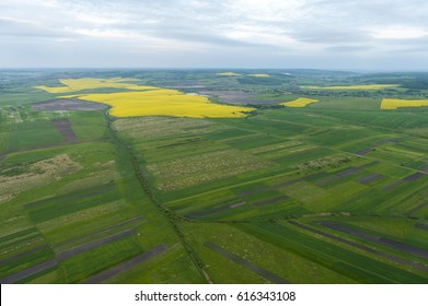 Aerial view on green and yellow parts of fields and countryside
