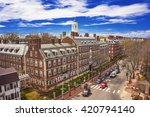 Aerial view on John Kennedy Street in the Harvard University Area in Cambridge, Massachusetts, the USA. Eliot House white belltower seen on the background. Tourists in the street