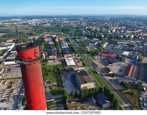 Aerial\
view on red brick chimney on a background of\
city.