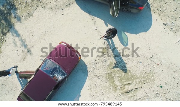 Aerial view on robbers with guns shot the car and
leave. Footage. Terrorist or car thief pointing a gun at the
driver. An armed man in the mask threatening pistol to the driver
of the car