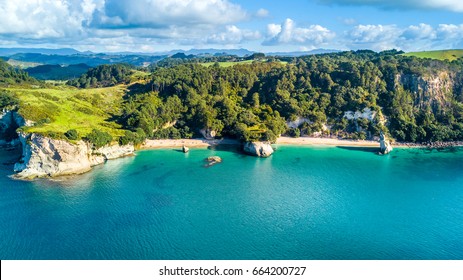 Aerial view on a small beach surrounded by rocks and forest. Coromandel, New Zealand

