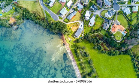 Aerial view on small suburb on a sunny ocean beach. Whangaparoa peninsula, Auckland, New Zealand