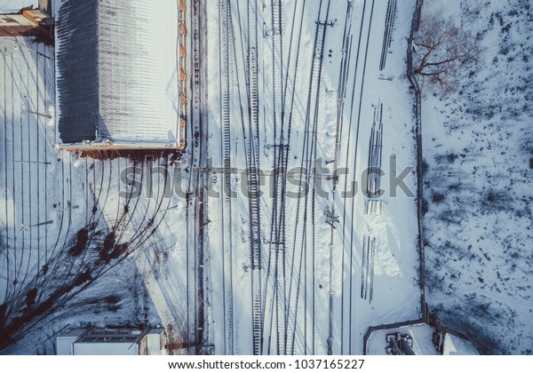Aerial view on snowy city, car traffic, bridge\
over railways, cars driving in\
city