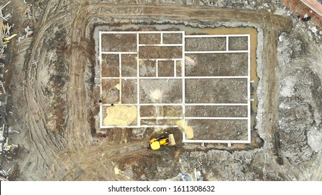 Aerial View On Top Building Foundation. The Excavator Brings Sand For The Foundation Of The House