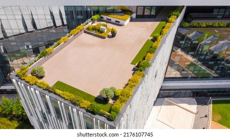 Aerial View On A Wooden Paved Terrace Of An Office Building. There Are Plants And Flowers But There Are No People.