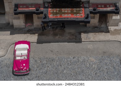 aerial view of one pink classic cabriolet  car with white leather interior (seats),  parked in front of a historic building  - Powered by Shutterstock