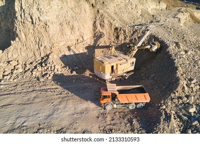 Aerial view of open pit mine of sandstone materials for construction industry with excavator loading dump truck with stones. Heavy equipment in mining and production of useful minerals concept - Shutterstock ID 2133310593