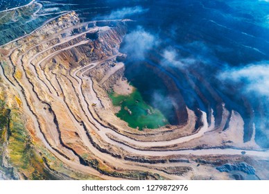 Aerial View Of Opencast Mining Quarry With Lots Of Machinery At Work - View From Above. 