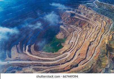 Aerial View Of Opencast Mining Quarry With Lots Of Machinery At Work - View From Above.