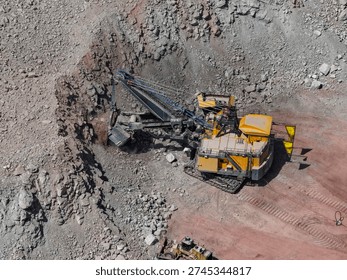 Aerial view of an open-pit mine in the process of mineral extraction with heavy machinery