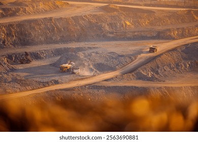 Aerial View of Open-Pit Mining Operation with Haul Trucks in a Quarry at Sunset.