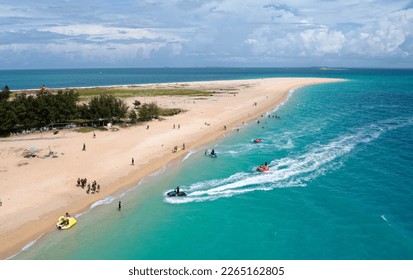Aerial view of outdoor enthusiasts enjoying jet skiing, banana boat riding and other water sports at a beautiful sandy beach on a sunny summer day, on Jibei Island, Baisha, Penghu County, Taiwan