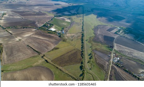Aerial view over the agricultural fields. Aerial top view photo from flying drone of a land with sown green fields in countryside in spring day.