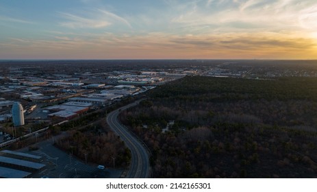 An aerial view over the Edgewood Oak Brush Plains Preserve in Deer Park, New York during a beautiful golden sunset taken by a drone camera.