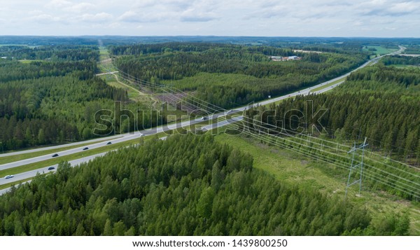 Aerial\
view over the highway. Forest and power\
lines.