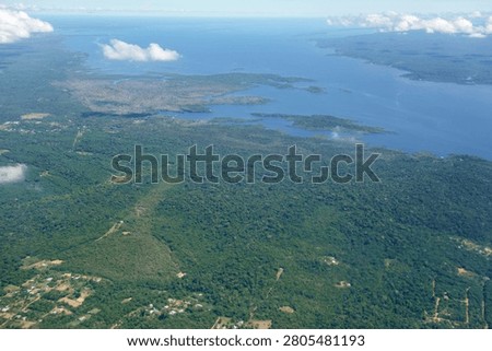 Aerial view over immense Amazon rainforest with a wide river cutting through forest. Amazonas, Brazil.