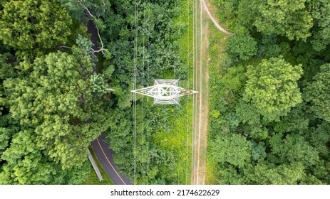 An Aerial View Over A Large Tower And Electrical Power Lines In The Midst Of Tall Green Trees On A Sunny Morning On Long Island, NY.