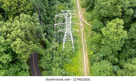 An Aerial View Over A Large Tower And Electrical Power Lines In The Midst Of Tall Green Trees On A Sunny Morning On Long Island, NY.