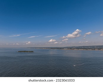 An aerial view over Lower Bay by Staten Island, New York on a beautiful day. The drone camera shows the calm waters near Hoffman Island.