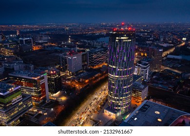 Aerial view over the modern office buildings and residential areas from the north part of Bucharest in the evening. Sky Tower sky scrapper in frame. Romania, 2022.