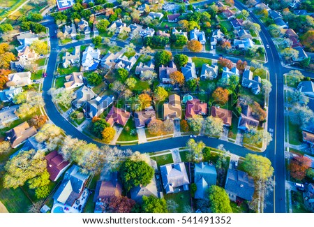 Aerial View Over Modern Suburb Home Community neighborhood with colorful Fall Autumn trees around curved streets and new development outside of Austin , Texas 