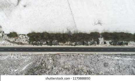 Aerial View Over Snowy Field And Road In New Zealand. Aerial Drone View Of Road In Idyllic Winter Landscape. Street Running Through The Nature From A Birds Eye View.