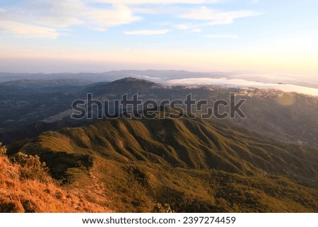 Aerial view overlooking rugged, rocky mountainous terrain with early morning sunlight from summit of Mt Ramelau in the districts of Timor-Leste, Southeast Asia