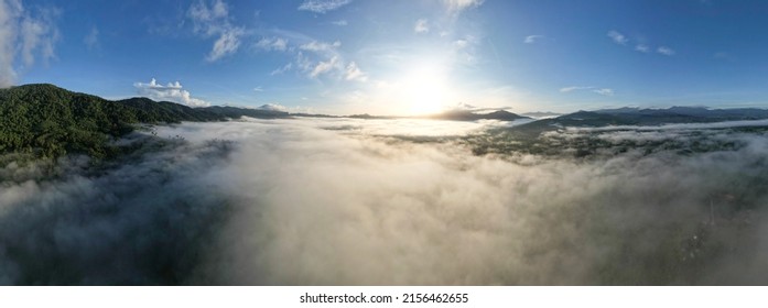 Aerial view Panorama of flowing fog waves on mountain tropical rainforest,Bird eye view image over the clouds Amazing nature background with clouds and mountain peaks in Thailand - Powered by Shutterstock