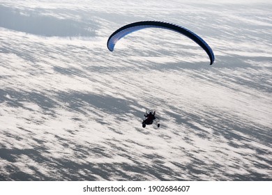 Ambiance paramoteur à vue aérienne ou parapente motorisé vu du ciel en France et survolant les champs enneigés en hiver