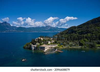 Aerial view of Parco Baia delle Sirene, Lake Garda, Italy. Panorama of punta san vigilio. Baia delle Sirene on the coastline. Top view of baia delle sirene on the coastline of Lake Garda. - Shutterstock ID 2096608879