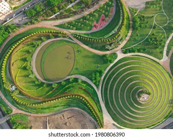 Aerial view of Parco del Portello in Milan, near CityLife, Lombardia. View from the height of park with a green lawn and paths. Abstract design similar to a dragon. Drone photography in Milano.