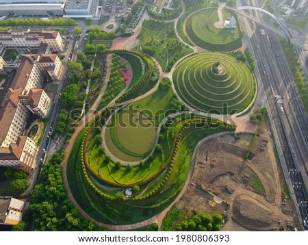 Aerial view of Parco del Portello in Milan, near CityLife, Lombardia. View from the height of park with a green lawn and paths. Abstract design similar to a dragon. Drone photography in Milano.