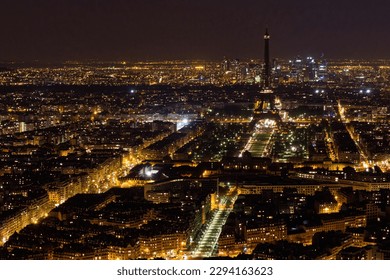 Vista aérea de París por la noche con una oscura Torre Eiffel y el barrio de negocios de La Défense como se ve en el Tour Montparnasse, Francia