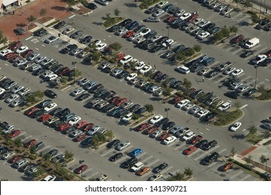 Aerial View Of A Parking Lot With Many Cars In Rows.