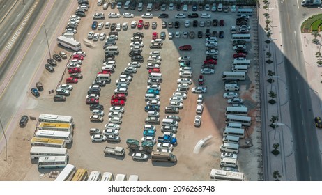 Aerial View Of A Parking Lot With Many Cars And Buses In Rows Timelapse During All Day With Shadows Moving Fast. Free Area On A Sand